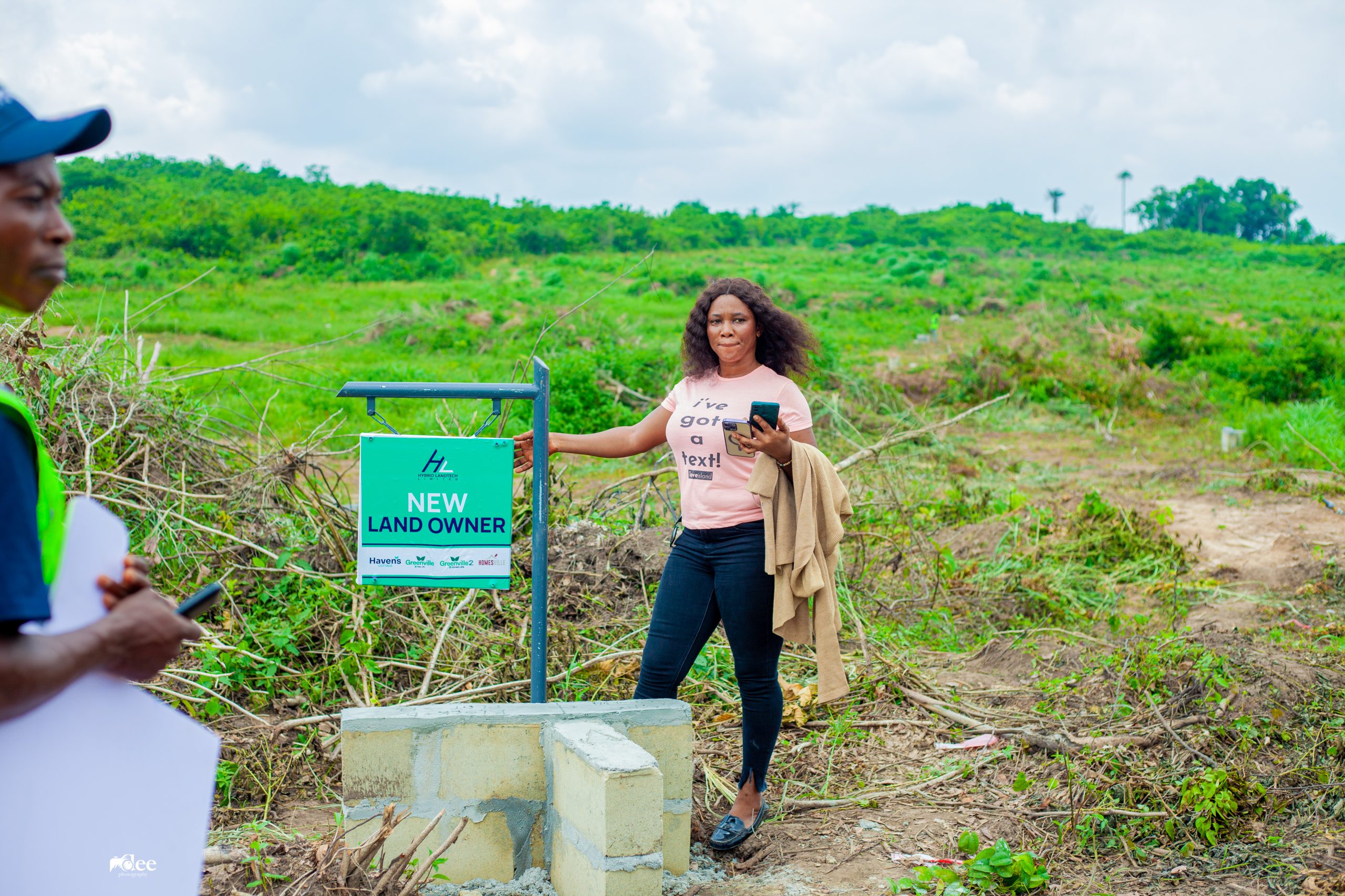 An investor poses by her plot during allocation at Greenville